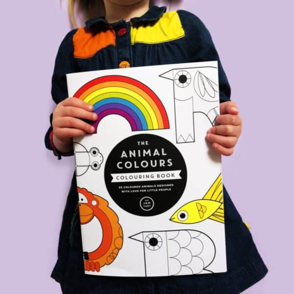 A child is holding the Animal Colours Colouring Book.