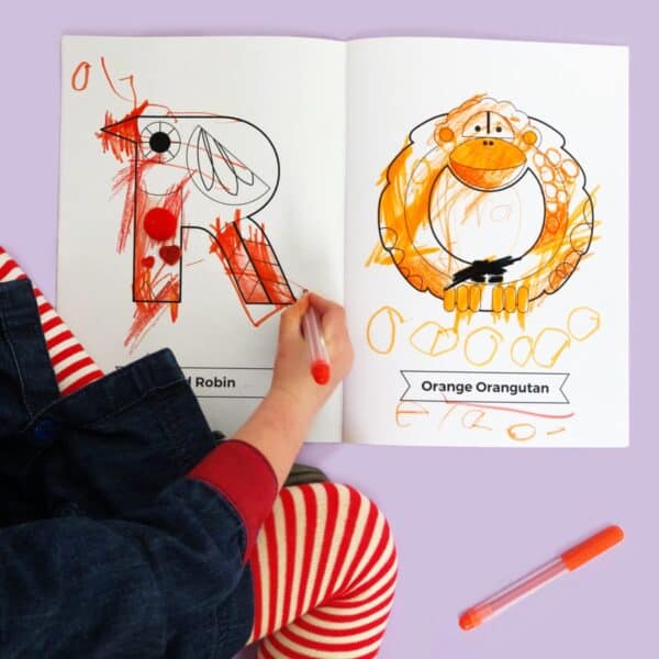 A child is colouring the Animal Colours Colouring Book.