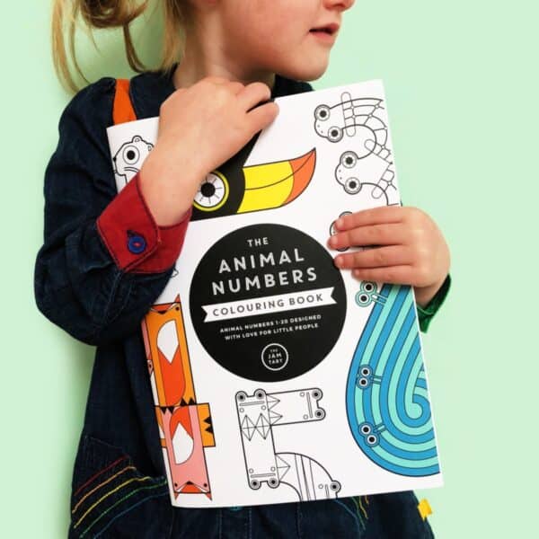 A child is holding the Animal Numbers Colouring Book.